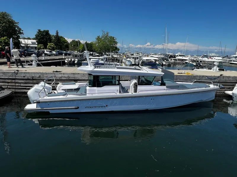 Slide: The Image of 2025 Axopar 37 XC CROSS CABIN boat docked at marina under clear blue sky. - 1
