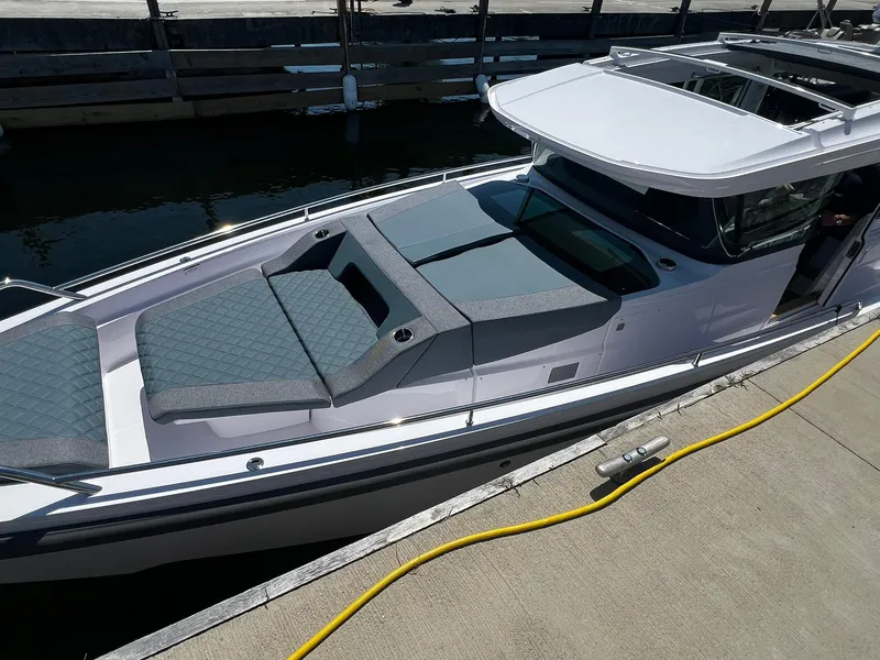 Slide: The Image of 2025 Axopar 37 XC CROSS CABIN boat docked, featuring sleek design and spacious seating. - 2