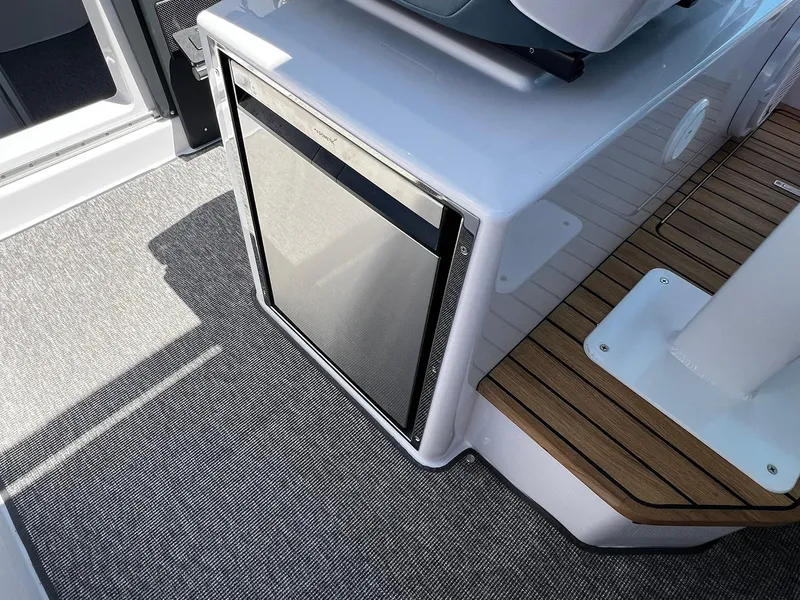Slide: The Image of 2025 Axopar 37 XC CROSS CABIN interior with compact fridge and stylish flooring. - 20