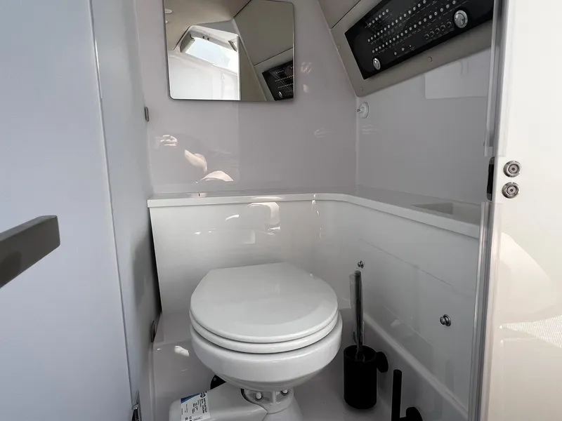 Slide: The Image of Bathroom interior of 2025 Axopar 37 XC CROSS CABIN, featuring modern toilet and mirror. - 26