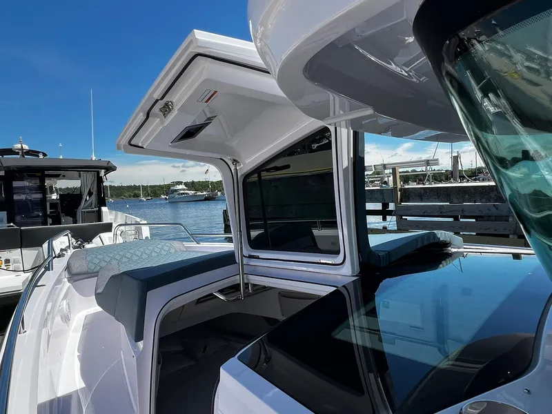 Slide: The Image of 2025 Axopar 37 XC CROSS CABIN boat docked, showcasing sleek design and open cabin. - 5