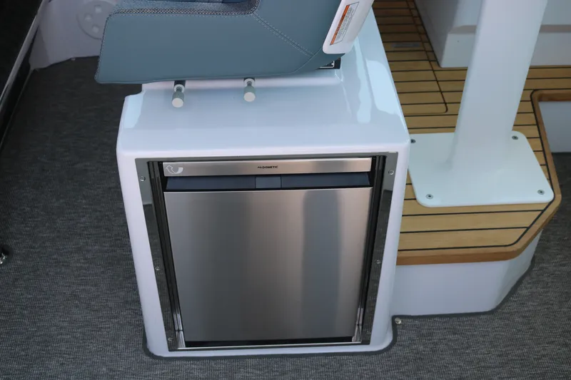Slide: The Image of 2025 Axopar 37 XC Cross Cabin interior with compact Dometic fridge and modern seating. - 13