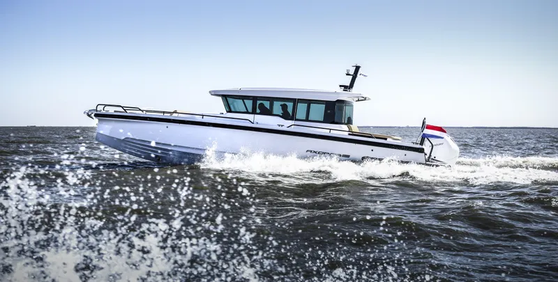 Slide: The Image of 2025 Axopar 37 XC Cross Cabin with dual Mercury outboard engines at a boat show. - 4
