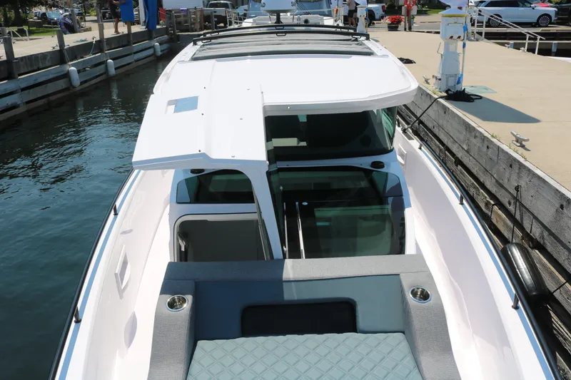 Slide: The Image of 2025 Axopar 37 XC Cross Cabin boat docked at marina, showcasing sleek design and spacious cabin. - 11