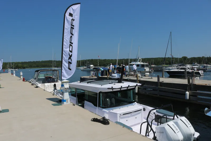 Slide: The Image of 2025 Axopar 37 XC Cross Cabin docked at marina with Axopar flag. - 1