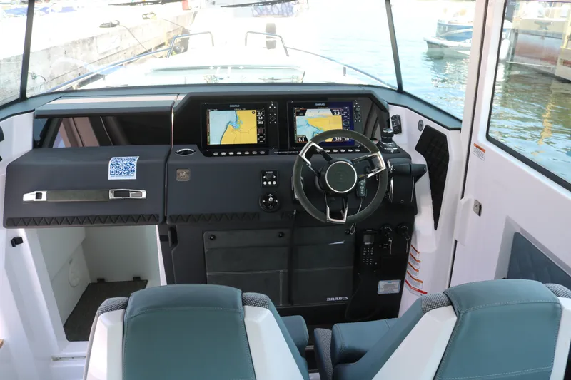 Slide: The Image of 2025 Axopar 37 XC Cross Cabin helm with dual navigation screens and modern steering wheel. - 15
