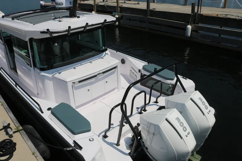 Slide: The Image of 2025 Axopar 37 XC Cross Cabin boat docked with twin Mercury 300 V8 engines. - 8