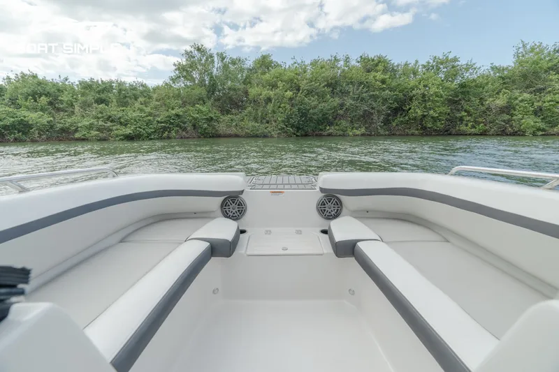 Slide: The Image of 2024 Starcraft SVX 210 OB DC boat interior with seating, on a calm lake. - 10