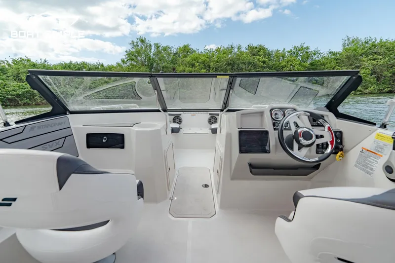 Slide: The Image of 2024 Starcraft SVX 210 OB DC boat interior with steering wheel and seating. - 7
