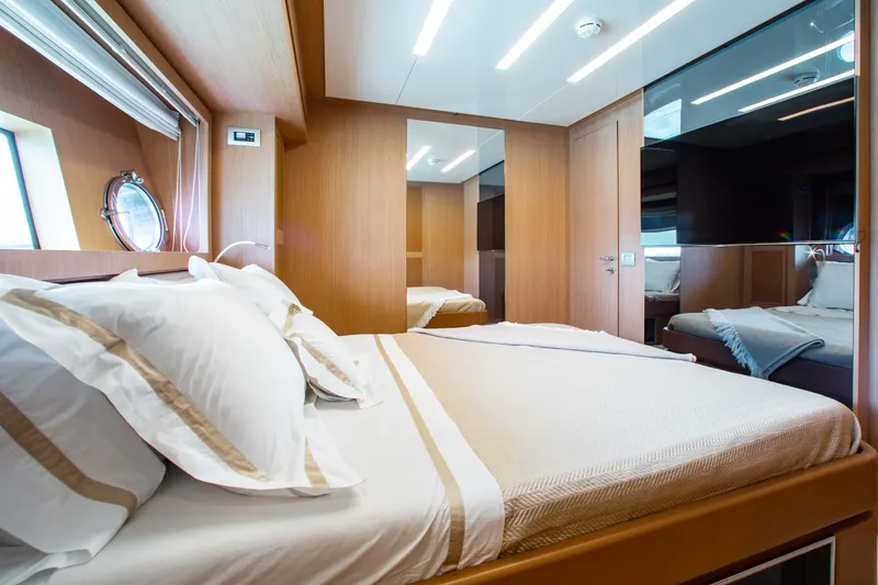 Slide: The Image of Luxurious bedroom interior on a 2016 Riva 88' Florida yacht, featuring elegant wood finishes. - 16