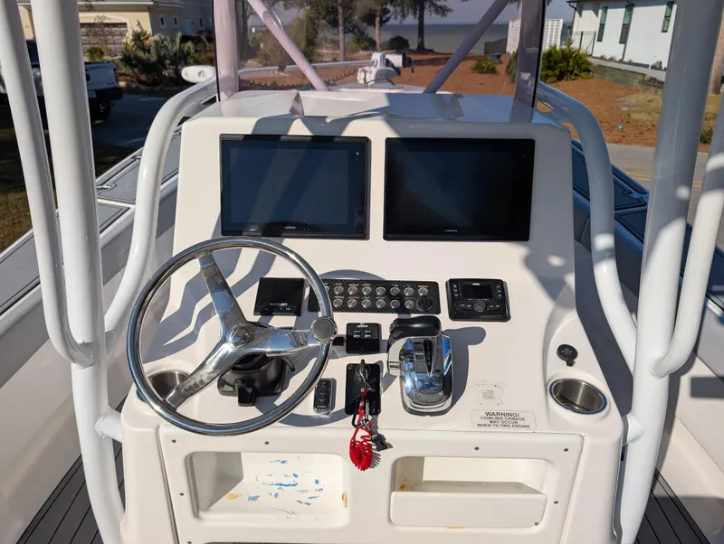 Slide: The Image of 2020 Blue Wave 2800 Makaira boat dashboard with steering wheel and dual screens. - 16