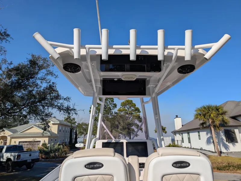 Slide: The Image of 2020 Blue Wave 2800 Makaira boat with T-top and rod holders, parked in residential area. - 19