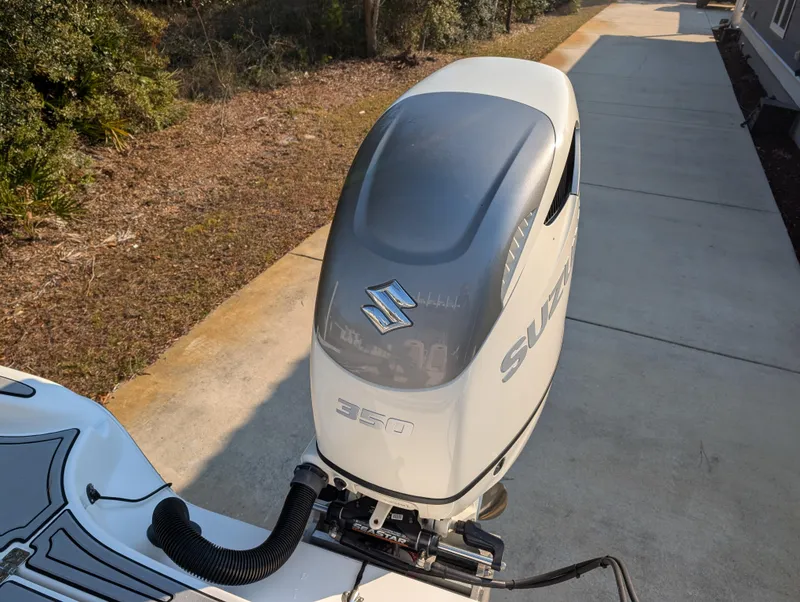 Slide: The Image of 2020 Blue Wave 2800 Makaira with Suzuki 350 outboard engine, parked on a driveway. - 34