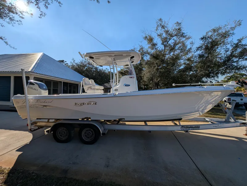 Slide: The Image of 2020 Blue Wave 2800 Makaira boat on trailer, parked in driveway, under clear blue sky. - 4