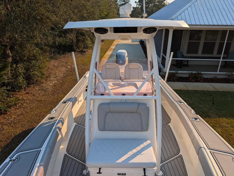 Slide: The Image of 2020 Blue Wave 2800 Makaira boat, white interior, parked near a house. - 46
