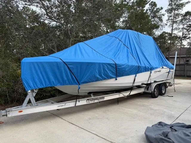 Slide: The Image of 2020 Blue Wave 2800 Makaira boat covered with blue tarp on trailer. - 48