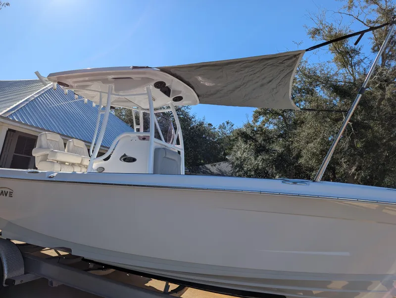 Slide: The Image of 2020 Blue Wave 2800 Makaira boat with canopy, parked outdoors under clear sky. - 8