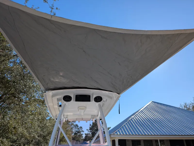 Slide: The Image of 2020 Blue Wave 2800 Makaira boat with canopy, viewed from below against blue sky. - 9