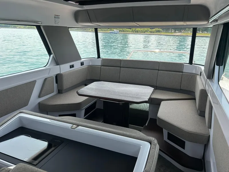 Slide: The Image of Interior of 2025 Axopar 45 XC Cross Cabin with seating and table, overlooking water. - 16