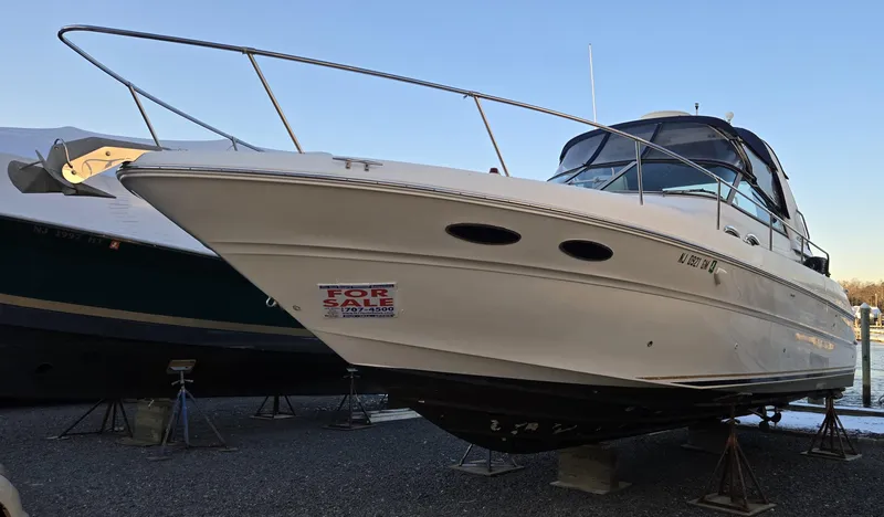 The Image of 2000 Sea Ray 310 Sundancer boat for sale, displayed on stands. - 0