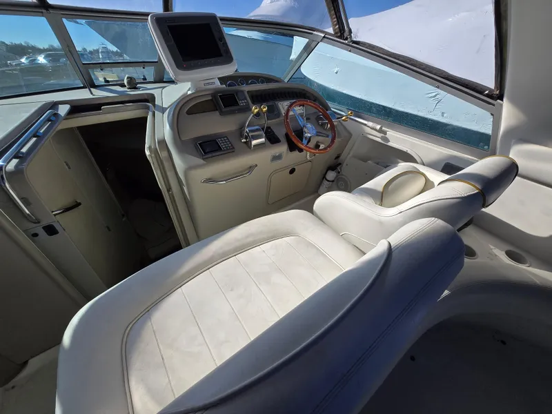 Slide: The Image of 2000 Sea Ray 310 Sundancer helm with leather seating and modern controls. - 11