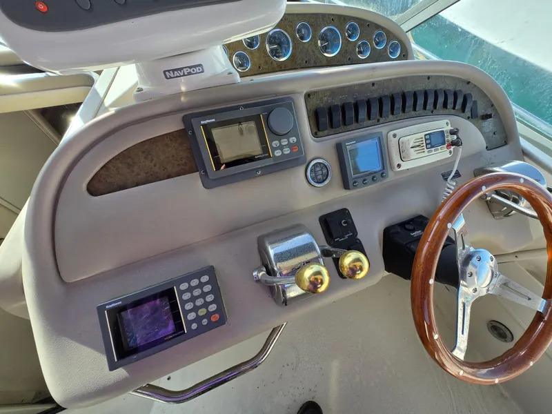 Slide: The Image of Control panel of a 2000 Sea Ray 310 Sundancer boat with steering wheel and navigation instruments. - 14