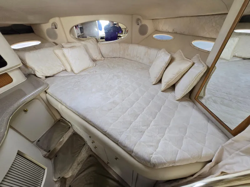 Slide: The Image of 2000 Sea Ray 310 Sundancer cabin with plush bedding and cozy interior design. - 21