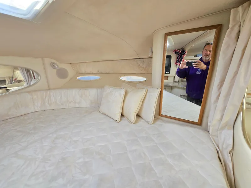 Slide: The Image of Interior cabin of 2000 Sea Ray 310 Sundancer with bed, pillows, and mirror. - 23