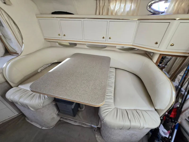 Slide: The Image of Interior of 2000 Sea Ray 310 Sundancer with cushioned seating and table. - 27