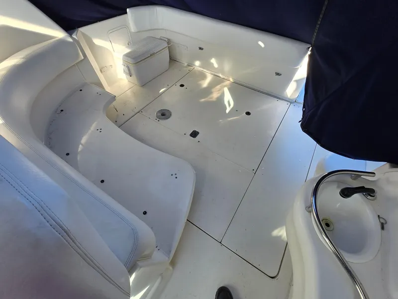 Slide: The Image of 2000 Sea Ray 310 Sundancer boat interior with white seating and compact sink area. - 3