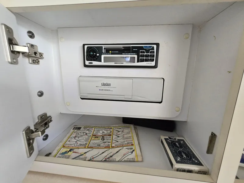 Slide: The Image of Cabinet with Clarion stereo system, instruction manual, and playing cards on Sea Ray 310 Sundancer. - 30