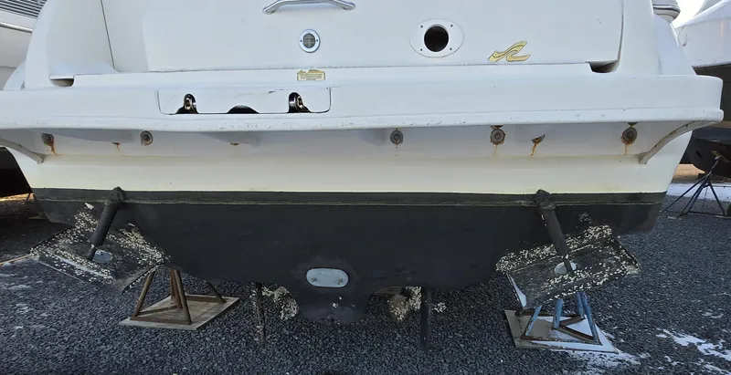 Slide: The Image of Rear view of a 2000 Sea Ray 310 Sundancer boat on stands, showing hull and propellers. - 31