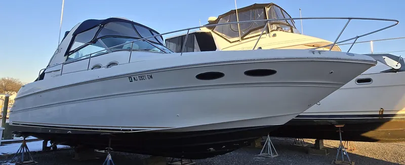 Slide: The Image of 2000 Sea Ray 310 Sundancer boat on stands, side view, with clear blue sky. - 4