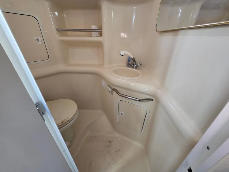 Slide: The Image of 2000 Sea Ray 310 Sundancer bathroom with sink, toilet, and storage compartments. - 6