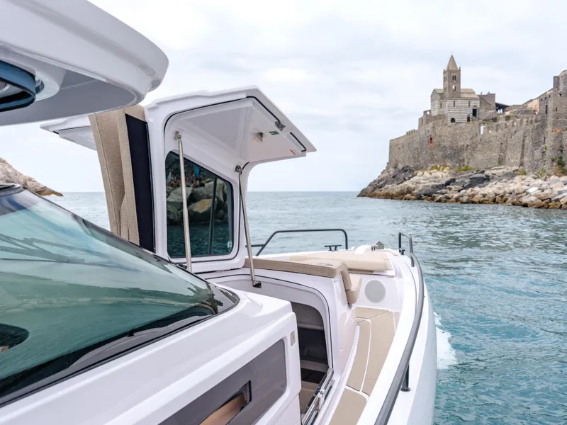 Slide: The Image of 2025 Axopar 45 SUN TOP boat near historic coastal fortress. - 16