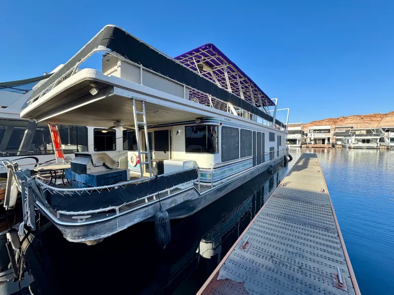 Slide: The Image of 1997 Sumerset Johnny Quest Trip #33 houseboat docked on calm water. - 1