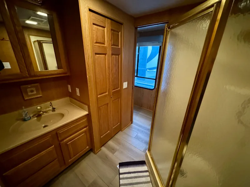 Slide: The Image of Bathroom interior of 1997 Sumerset Johnny Quest Trip #33, featuring wood cabinetry and glass shower. - 14