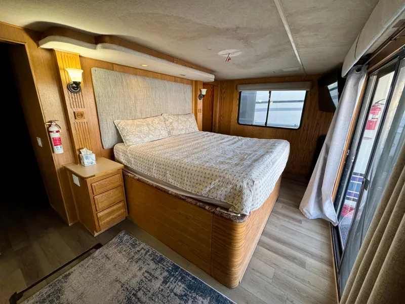 Slide: The Image of Cozy bedroom in 1997 Sumerset Johnny Quest Trip #33 houseboat with wood paneling and large windows. - 15