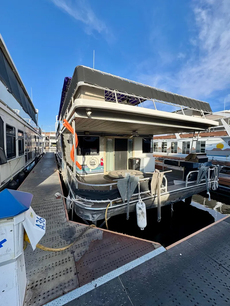Slide: The Image of 1997 Sumerset Johnny Quest Trip #33 houseboat docked at marina under clear blue sky. - 25