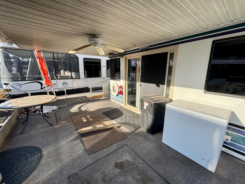 Slide: The Image of 1997 Sumerset Johnny Quest Trip #33 houseboat deck with table, ceiling fan, and sliding door. - 6