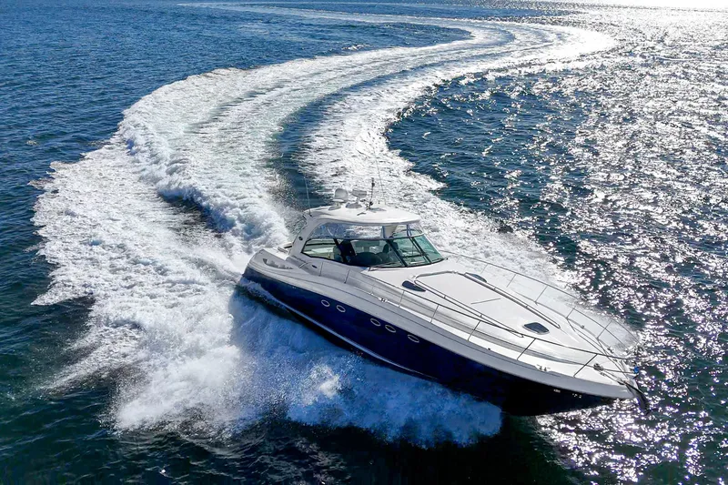 Slide: The Image of 2005 Sea Ray 500 Sundancer cruising on open water, creating a dynamic wake. - 0
