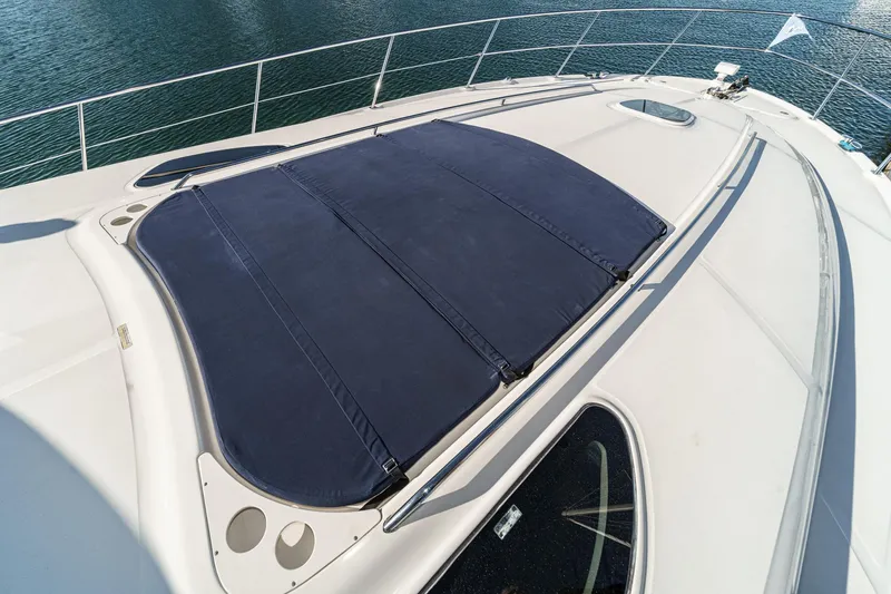 Slide: The Image of 2005 Sea Ray 500 Sundancer yacht deck with sunpad, overlooking calm water. - 29