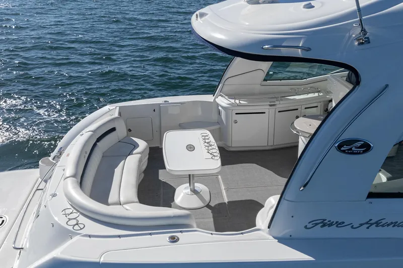 Slide: The Image of 2005 Sea Ray 500 Sundancer yacht with spacious deck seating and table on open water. - 36