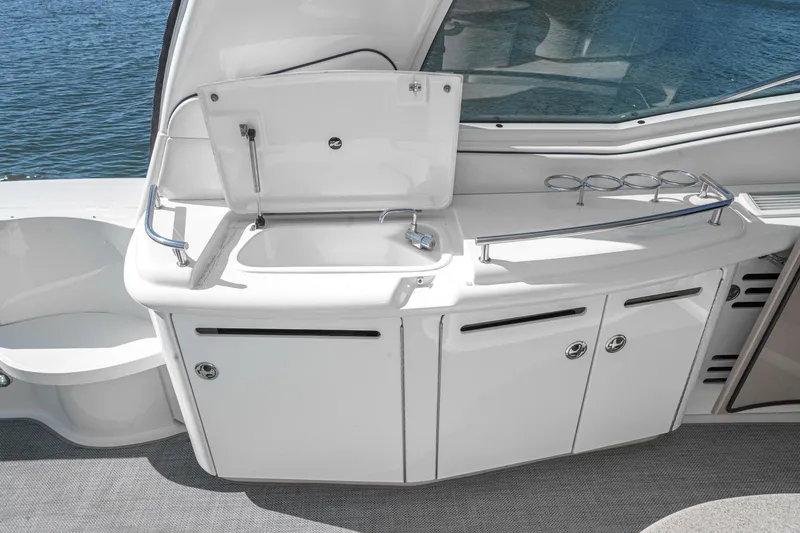 Slide: The Image of 2005 Sea Ray 500 Sundancer yacht kitchenette with sink and storage, overlooking water. - 39