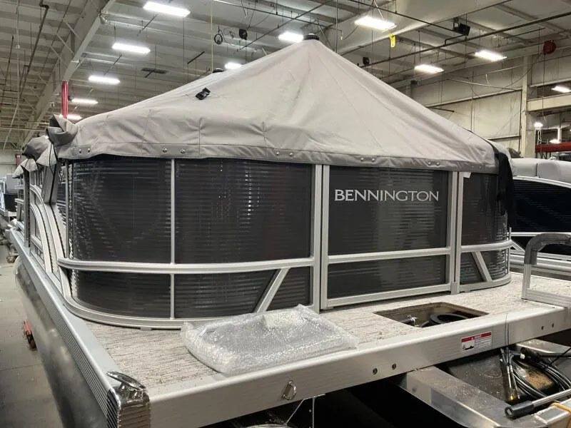 Slide: The Image of 2025 Bennington 20 S STERN RADIUS pontoon boat with cover in a warehouse setting. - 8