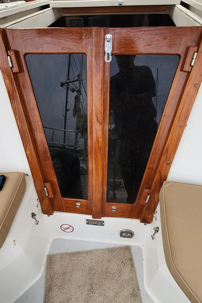 Slide: The Image of 1995 Catalina 42 MkII sailboat cabin entrance with wooden doors and cushioned seating. - 15