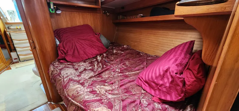 Slide: The Image of Cozy cabin interior of 1995 Catalina 42 MkII with red bedding and wooden accents. - 32