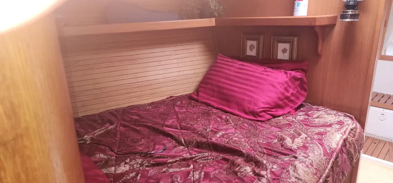 Slide: The Image of Cozy cabin interior of 1995 Catalina 42 MkII with red bedding and wooden accents. - 33