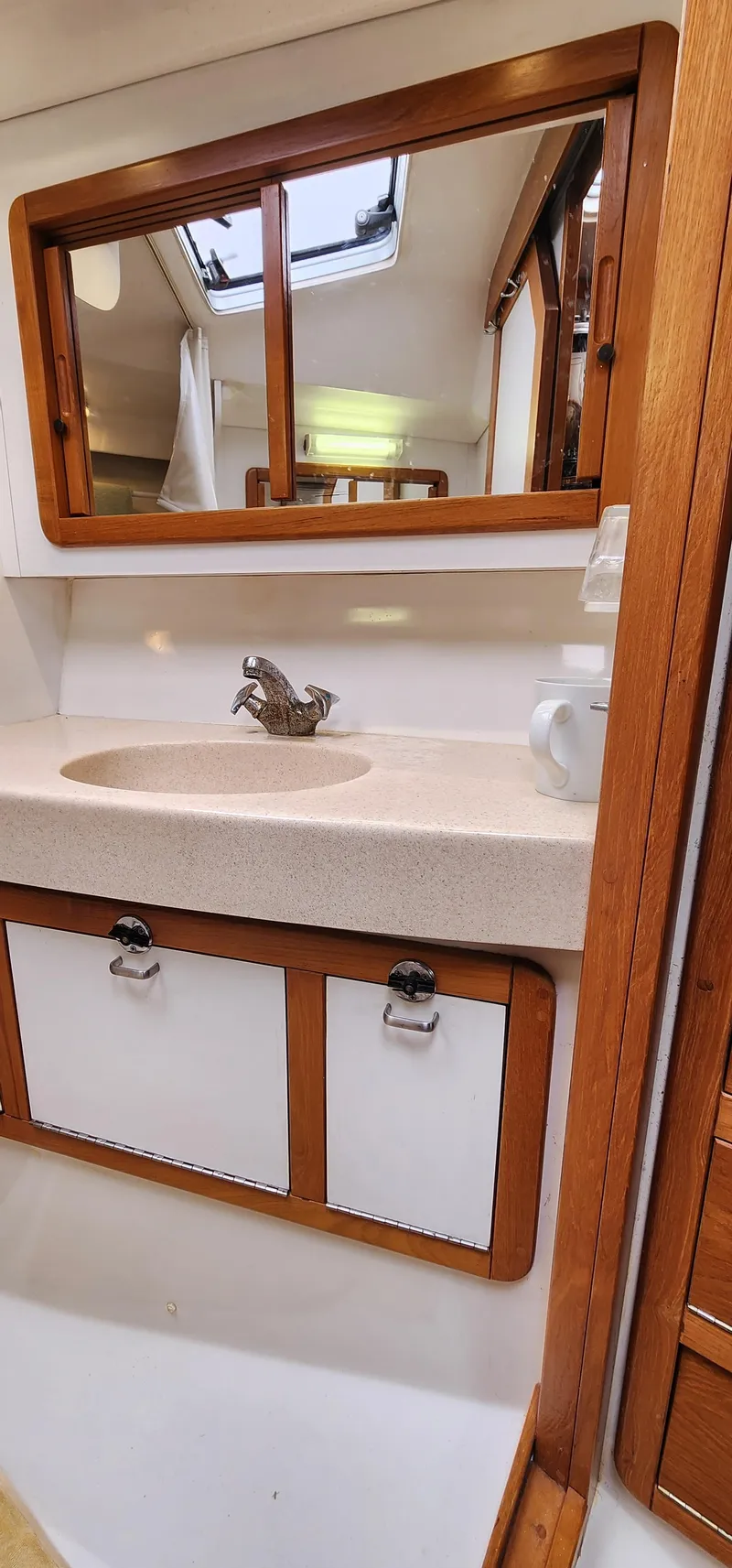 Slide: The Image of Catalina 42 MkII 1995 yacht bathroom with sink, mirror, and wooden cabinetry. - 38