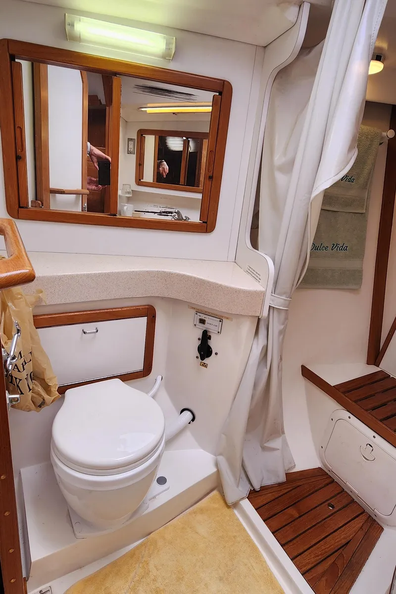 Slide: The Image of 1995 Catalina 42 MkII yacht bathroom with toilet, mirror, and wooden accents. - 39